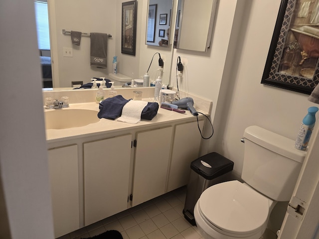 half bathroom featuring toilet, tile patterned flooring, and vanity