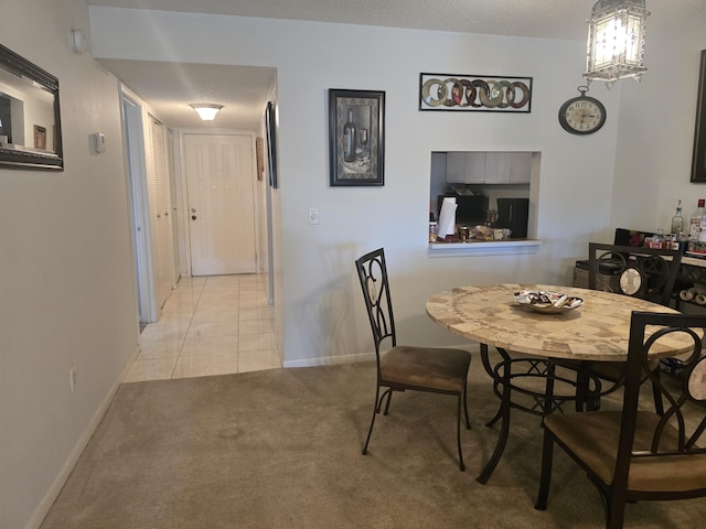 dining space with carpet floors, baseboards, and tile patterned flooring