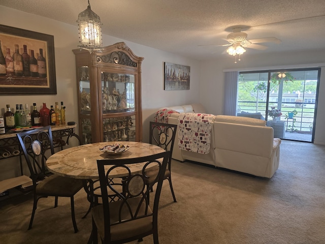 dining area with carpet flooring, a textured ceiling, and a ceiling fan