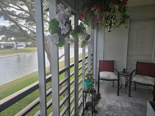 sunroom / solarium featuring a water view