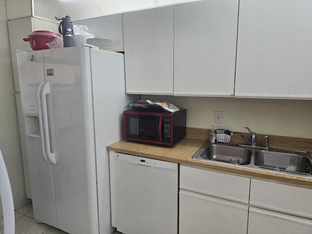 kitchen featuring a sink, light tile patterned floors, light countertops, white appliances, and white cabinetry