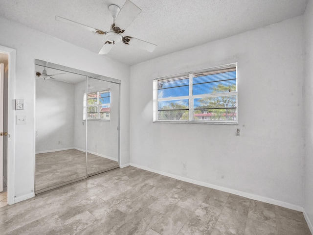 19 Abbey Ln Unit 203, Delray Beach, FL 33446 - unfurnished bedroom featuring baseboards, a textured ceiling, ceiling fan, and a closet