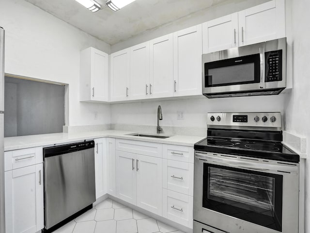 19 Abbey Ln Unit 203, Delray Beach, FL 33446 - kitchen featuring light tile patterned flooring, light countertops, white cabinetry, a sink, and appliances with stainless steel finishes
