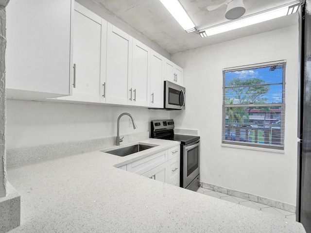 19 Abbey Ln Unit 203, Delray Beach, FL 33446 - kitchen featuring a sink, appliances with stainless steel finishes, white cabinets, and light stone countertops