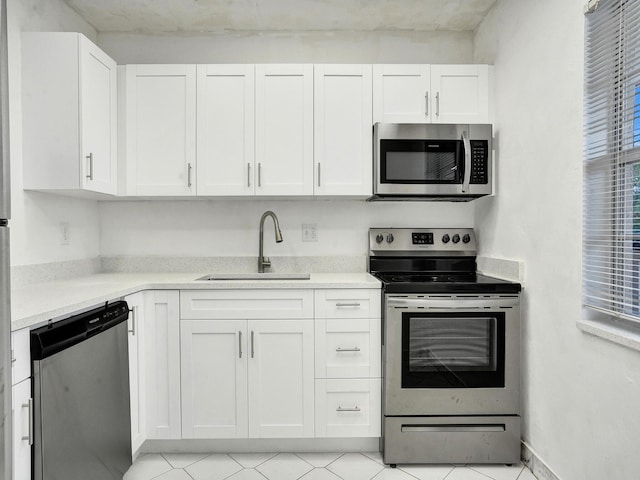 19 Abbey Ln Unit 203, Delray Beach, FL 33446 - kitchen with a sink, appliances with stainless steel finishes, white cabinetry, and light countertops