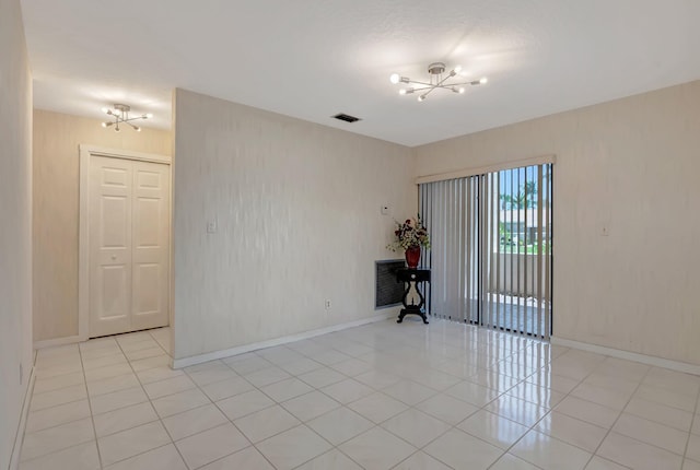 21065 Escondido Way, Boca Raton, FL 33433 - empty room with a chandelier, light tile patterned floors, and baseboards