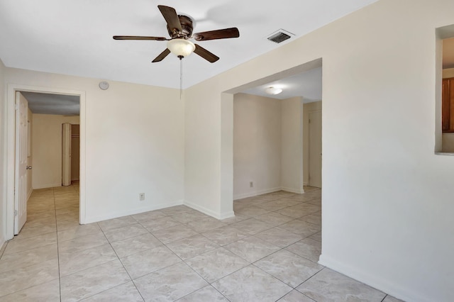 unfurnished room featuring ceiling fan, light tile patterned floors, and baseboards