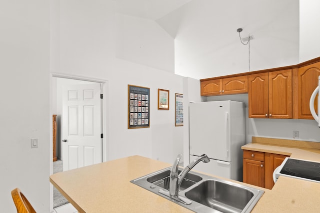 460 NW Turin Ct, Port Saint Lucie, FL 34986 - kitchen featuring white appliances, a sink, light countertops, high vaulted ceiling, and brown cabinetry