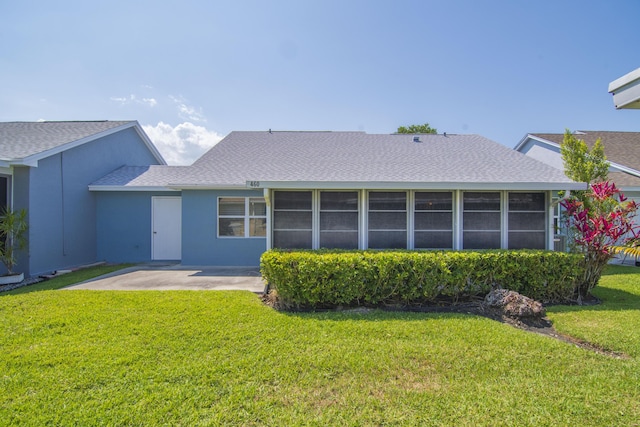 460 NW Turin Ct, Port Saint Lucie, FL 34986 - rear view of house with a sunroom, a lawn, a shingled roof, a patio, and stucco siding