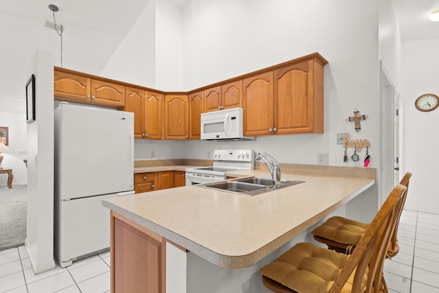 460 NW Turin Ct, Port Saint Lucie, FL 34986 - kitchen with white appliances, a towering ceiling, a sink, a peninsula, and light tile patterned floors