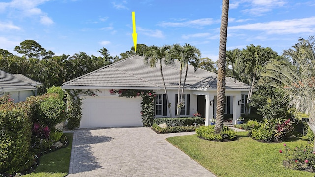 10841 SE Arielle Ter, Jupiter, FL 33469 - single story home featuring an attached garage, decorative driveway, a front lawn, and a tiled roof