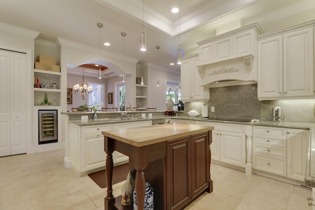 10841 SE Arielle Ter, Jupiter, FL 33469 - kitchen featuring open shelves, wood counters, a peninsula, wine cooler, and ornamental molding
