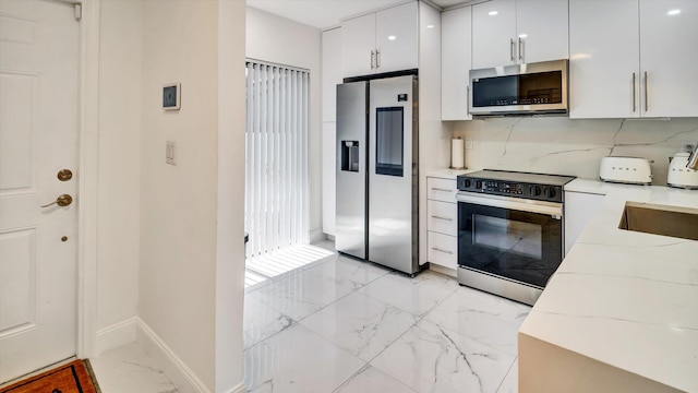 6320 Wedgewood Ter Unit 6320, Tamarac, FL 33321 - kitchen with tasteful backsplash, baseboards, marble finish floor, stainless steel appliances, and white cabinetry