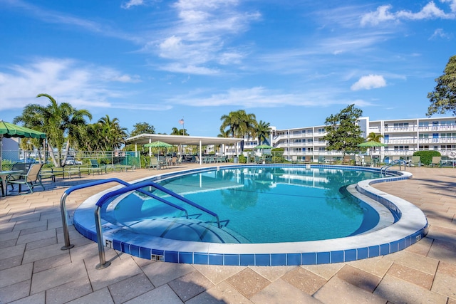 community pool featuring fence and a patio