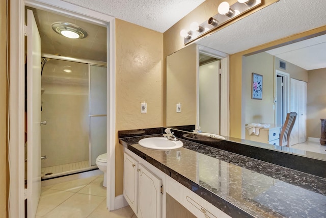 bathroom featuring vanity, a textured ceiling, a stall shower, and toilet