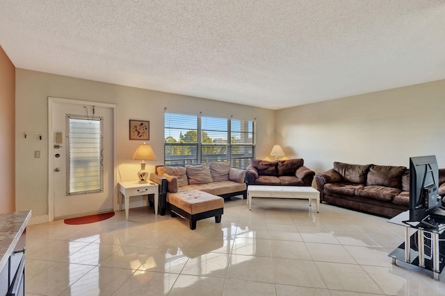 living area with a textured ceiling and light tile patterned floors