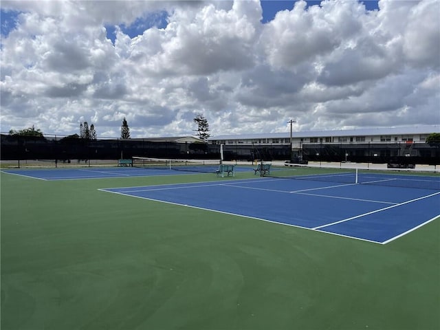 view of tennis court featuring fence and community basketball court