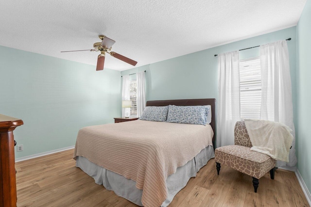 10124 182nd Ct S, Boca Raton, FL 33498 - bedroom with multiple windows, light wood-style flooring, ceiling fan, and a textured ceiling