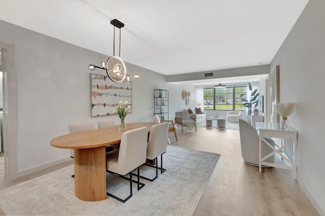 6049 Balboa Cir Unit 106, Boca Raton, FL 33433 - dining space featuring baseboards, light wood finished floors, a chandelier, and visible vents