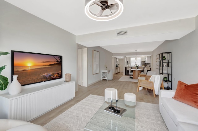 6049 Balboa Cir Unit 106, Boca Raton, FL 33433 - living area featuring a notable chandelier, visible vents, and light wood finished floors
