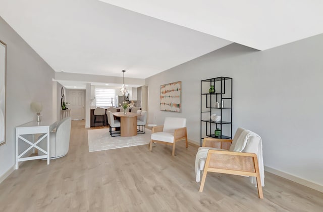 6049 Balboa Cir Unit 106, Boca Raton, FL 33433 - living area featuring baseboards, light wood-type flooring, and a notable chandelier