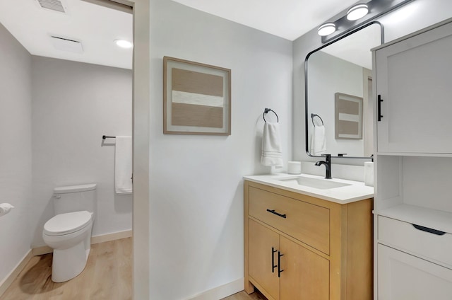 6049 Balboa Cir Unit 106, Boca Raton, FL 33433 - bathroom featuring visible vents, vanity, wood finished floors, toilet, and baseboards