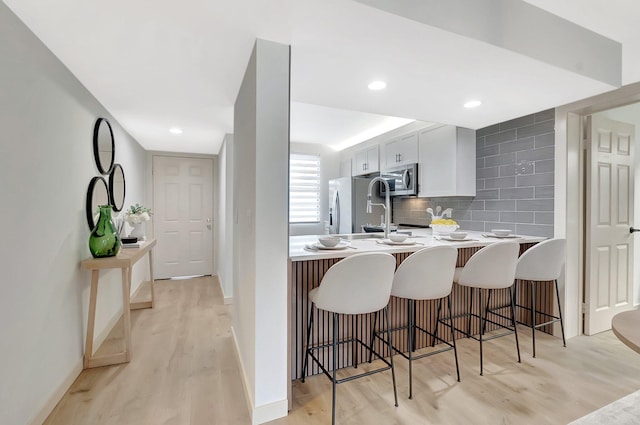 6049 Balboa Cir Unit 106, Boca Raton, FL 33433 - kitchen with a kitchen breakfast bar, stainless steel appliances, and light wood-type flooring