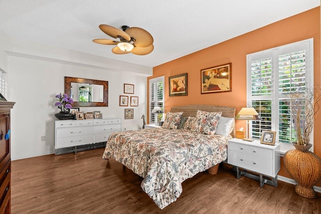 bedroom with a ceiling fan, wood finished floors, and multiple windows