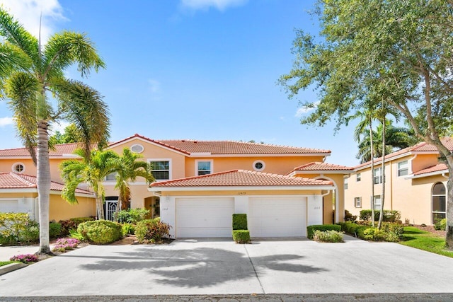 view of front facade with an attached garage, stucco siding, driveway, and a tile roof