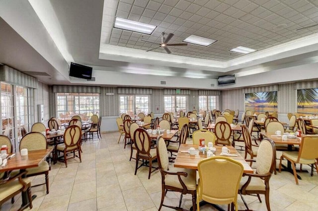 dining area featuring a healthy amount of sunlight, a raised ceiling, and visible vents
