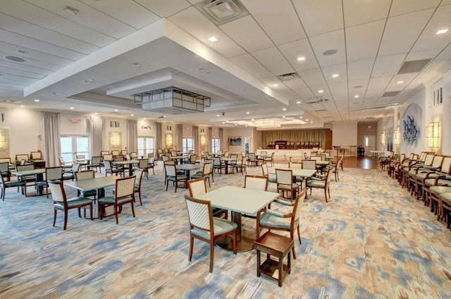 dining room featuring light colored carpet, a tray ceiling, and visible vents