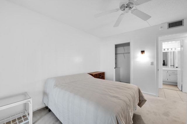 bedroom featuring visible vents, a closet, ceiling fan, light colored carpet, and light tile patterned floors