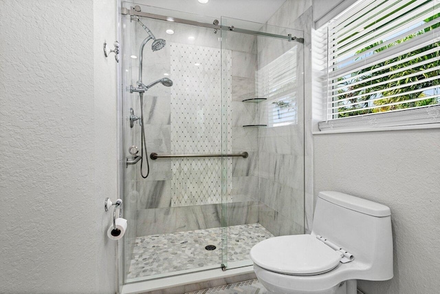 full bath featuring toilet, a textured wall, and a stall shower