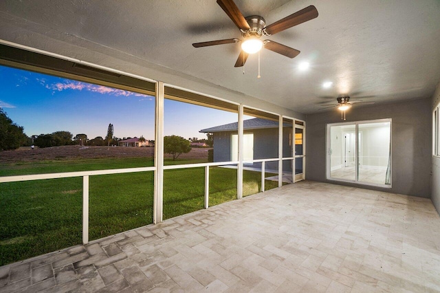 unfurnished sunroom featuring a ceiling fan