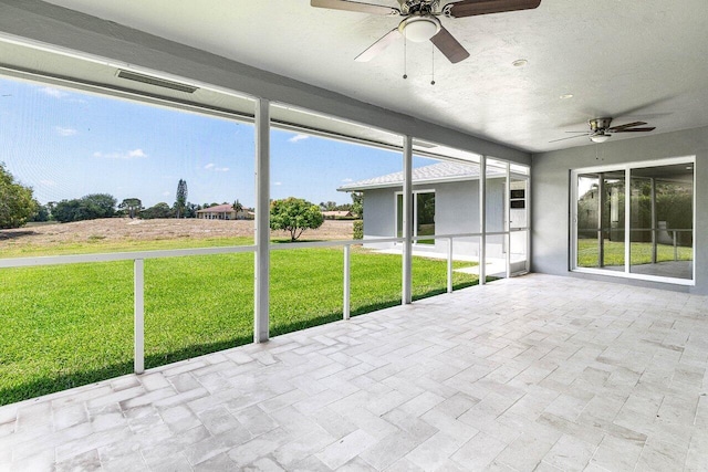 unfurnished sunroom with a ceiling fan