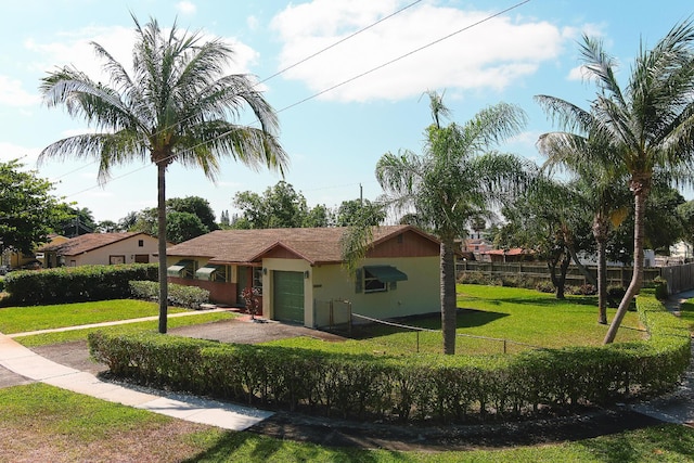 view of front of house featuring fence private yard, an attached garage, stucco siding, and a front yard