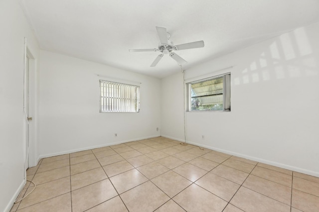 unfurnished room with light tile patterned floors, baseboards, plenty of natural light, and a ceiling fan