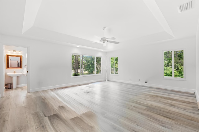 17225 Mare Ln, Loxahatchee, FL 33470 - unfurnished room featuring a tray ceiling, a ceiling fan, a sink, light wood-style flooring, and baseboards