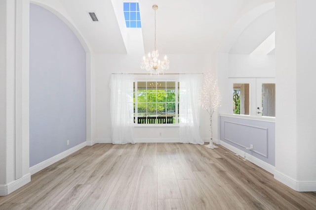17225 Mare Ln, Loxahatchee, FL 33470 - unfurnished dining area with a chandelier, wood finished floors, arched walkways, and baseboards