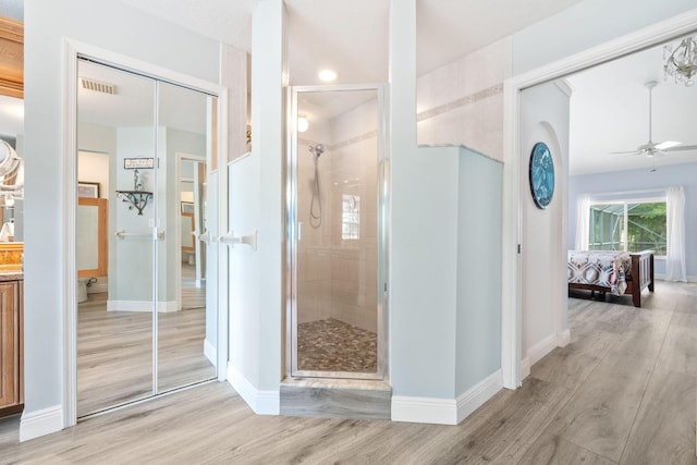 17225 Mare Ln, Loxahatchee, FL 33470 - ensuite bathroom featuring a stall shower, wood finished floors, a ceiling fan, and baseboards