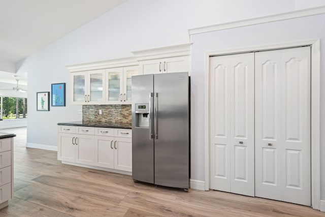 17225 Mare Ln, Loxahatchee, FL 33470 - kitchen featuring stainless steel fridge with ice dispenser, dark countertops, backsplash, glass insert cabinets, and baseboards