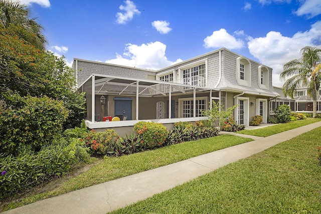 503 Vision Ct, Palm Beach Gardens, FL 33418 - back of house featuring a lawn, mansard roof, a balcony, and stucco siding