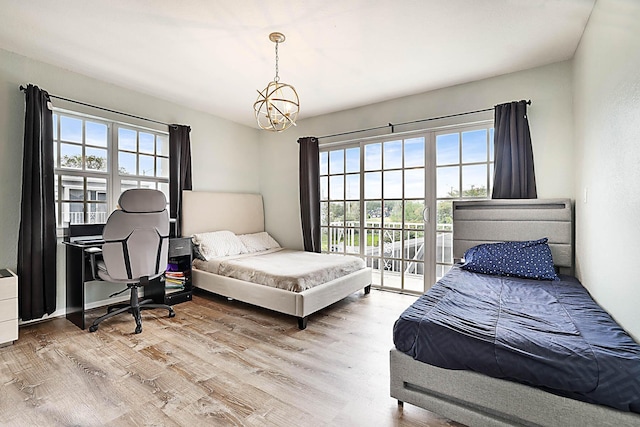 503 Vision Ct, Palm Beach Gardens, FL 33418 - bedroom with multiple windows, access to exterior, wood finished floors, and a notable chandelier