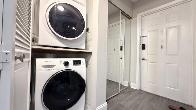 2925 SW 22nd Ave Unit 2030, Delray Beach, FL 33445 - washroom featuring stacked washer / dryer, wood finished floors, and baseboards