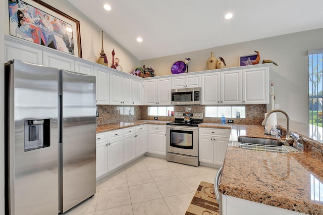 kitchen with backsplash, stainless steel appliances, white cabinets, and a sink