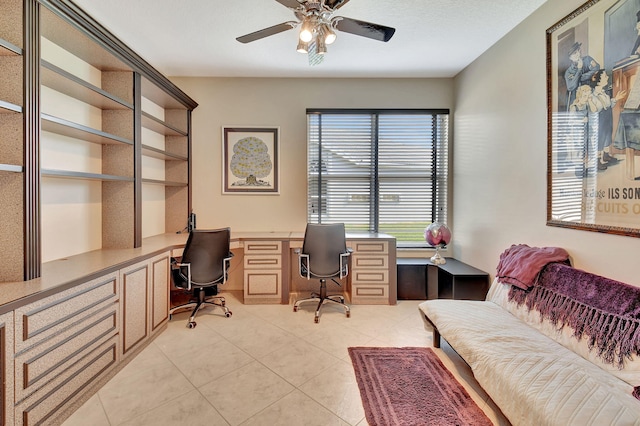 home office with ceiling fan, light tile patterned floors, and built in study area