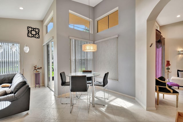 dining space with arched walkways, baseboards, and a healthy amount of sunlight