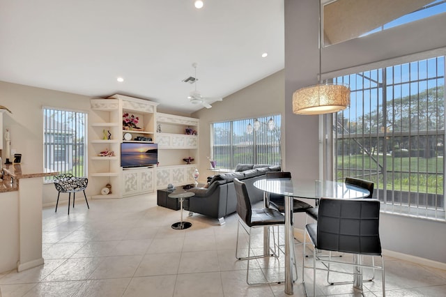 dining area featuring baseboards, lofted ceiling, a healthy amount of sunlight, and visible vents