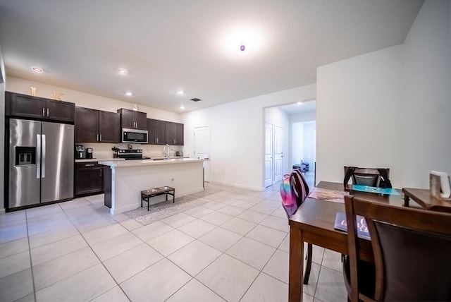 8633 Via, Mar Rosso, Lake Worth, FL 33467 - kitchen with light tile patterned flooring, dark brown cabinets, light countertops, a kitchen island with sink, and stainless steel appliances