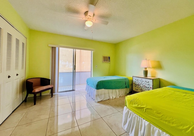 bedroom featuring a ceiling fan, a textured ceiling, access to exterior, tile patterned flooring, and a closet